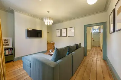 a living room with a blue couch and a tv at Liverpool Georgian Townhouse for Family & Groups in Liverpool