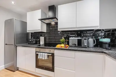 a white kitchen with white cabinets and appliances at Premium 4bedroom City Home Close to LFC in Liverpool