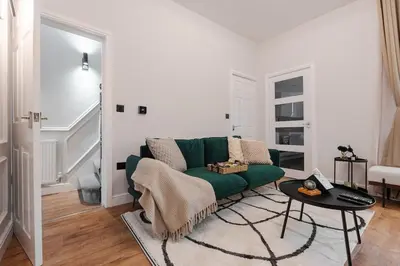 a living room with a green couch and a table at Premium 4bedroom City Home Close to LFC in Liverpool
