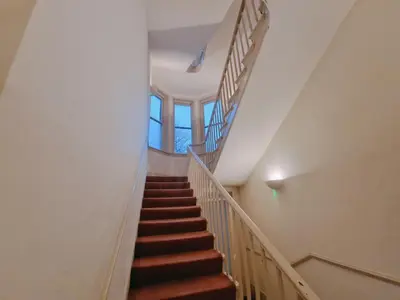 a staircase in a house with brown stairs at Modern Victorian Charm in a Great Location in Liverpool