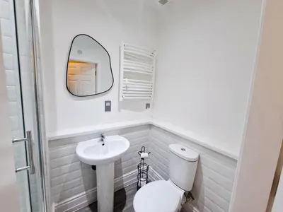 a white bathroom with a toilet and a sink at Modern Victorian Charm in a Great Location in Liverpool