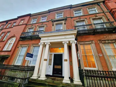 a red brick building with white columns and a door at Modern Victorian Charm in a Great Location in Liverpool
