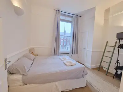 a bedroom with a bed and a large window at Modern Victorian Charm in a Great Location in Liverpool