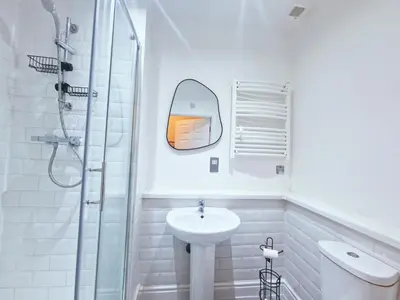 a white bathroom with a sink and a mirror at Modern Victorian Charm in a Great Location in Liverpool