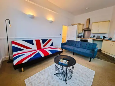 a living room with a couch and a table at Modern Victorian Charm in a Great Location in Liverpool