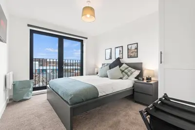 a bedroom with a large bed and a large window at Ideal for Getaways Liverpool Flat, sleeps 4 in Liverpool