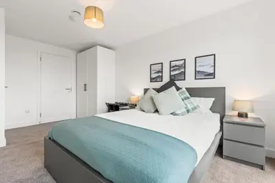 a bedroom with a large bed with a blue blanket at Ideal for Getaways Liverpool Flat, sleeps 4 in Liverpool
