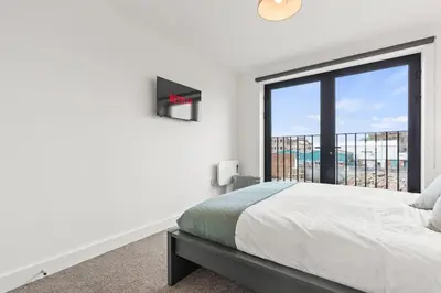 a bedroom with a bed and a large window at Ideal for Getaways Liverpool Flat, sleeps 4 in Liverpool