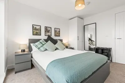 a white bedroom with a large bed and two lamps at Ideal for Getaways Liverpool Flat, sleeps 4 in Liverpool