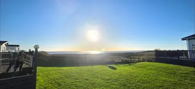 a view of the sun setting over a yard at Bay View Lodge in Heysham