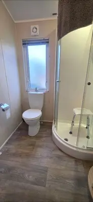 a bathroom with a toilet and a shower at Bay View Lodge in Heysham