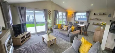 a living room with a couch and a tv at Bay View Lodge in Heysham