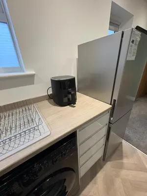 a kitchen with a refrigerator and a counter with a stove at Cleveleys Town Centre in Blackpool