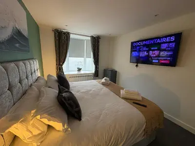 a bedroom with a bed with a television on the wall at Cleveleys Town Centre in Blackpool