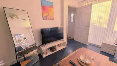 a living room with a flat screen tv and a mirror at Stylish 3BDR New Build Home In Everton Park in Liverpool