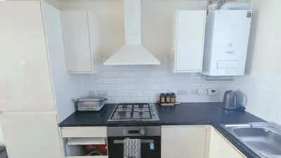 a kitchen with white cabinets and a stove top oven at Stylish 3BDR New Build Home In Everton Park in Liverpool