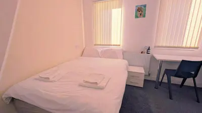 a small bedroom with a white bed and a desk at Stylish 3BDR New Build Home In Everton Park in Liverpool