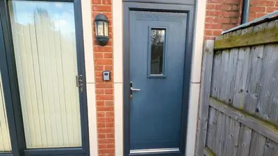 a blue door on a brick building with a fence at Stylish 3BDR New Build Home In Everton Park in Liverpool