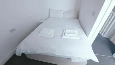 a small white bed with two white towels on it at Stylish 3BDR New Build Home In Everton Park in Liverpool