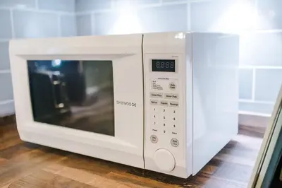 a microwave oven sitting on top of a wooden floor at Spacious 3 bedroom home with garden in Heapey