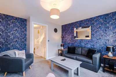 a living room with a couch and a table at Spacious 3 bedroom home with garden in Heapey
