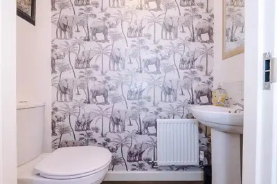 a bathroom with a toilet and a wallpaper with elephants at Spacious 3 bedroom home with garden in Heapey