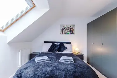 a bedroom with a bed with two towels on it at Spacious 3 bedroom home with garden in Heapey
