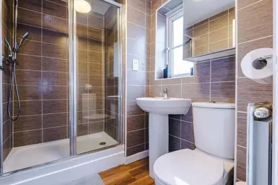 a bathroom with a shower and a toilet and a sink at Spacious 3 bedroom home with garden in Heapey