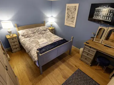 a bedroom with a bed and a desk and a mirror at The Gardeners Cottage at Lytham Hall in Lytham St Annes