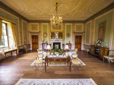 a living room with a table and chairs and a chandelier at The Gardeners Cottage at Lytham Hall in Lytham St Annes
