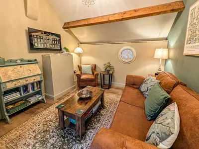 a living room with a couch and a table at The Gardeners Cottage at Lytham Hall in Lytham St Annes