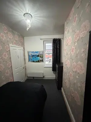 a bedroom with pink roses on the wall at Homey room in Liverpool