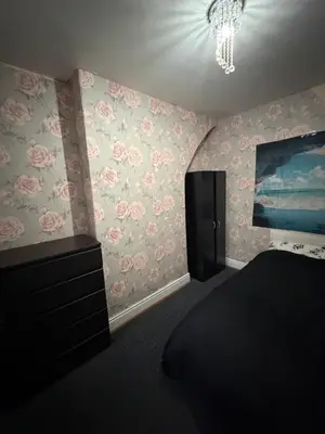a bedroom with pink flowers on the wall at Homey room in Liverpool