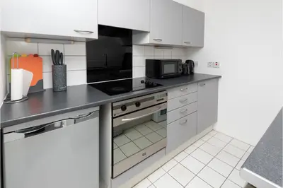 a kitchen with white cabinets and a stove top oven at Central Albert Dock 2Bed 2Bath in Liverpool
