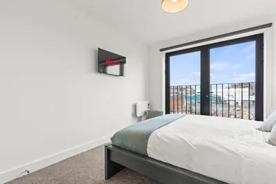 a bedroom with a bed and a large window at Business Stays, Modern Liverpool Flat, sleeps 4 in Liverpool