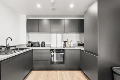 a kitchen with stainless steel appliances and a wooden floor at Business Stays, Modern Liverpool Flat, sleeps 4 in Liverpool