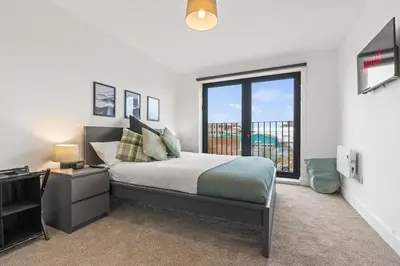 a bedroom with a bed and a large window at Business Stays, Modern Liverpool Flat, sleeps 4 in Liverpool