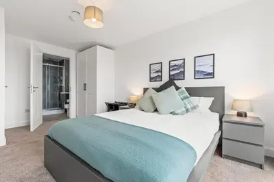 a bedroom with a large bed with a blue blanket at Business Stays, Modern Liverpool Flat, sleeps 4 in Liverpool