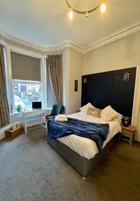 a bedroom with a large bed and a large window at Victoria suites in Southport