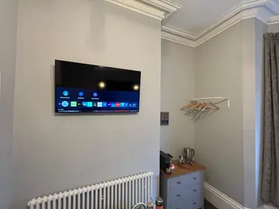a room with a flat screen tv on a wall at Victoria suites in Southport