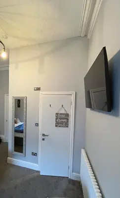 a room with a door and a television on a wall at Victoria suites in Southport