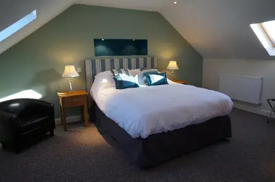 a bedroom with a large bed with blue pillows at Forest View Holiday Park in Burscough