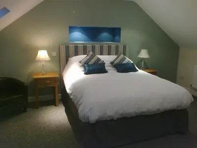 a bedroom with a large white bed with blue pillows at Forest View Holiday Park in Burscough