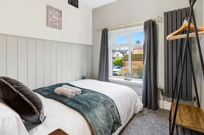a bedroom with a bed and a window at Spacious 4B home, great for contractors and families in Wigan
