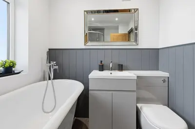 a bathroom with a tub and a sink and a toilet at Spacious 4B home, great for contractors and families in Wigan