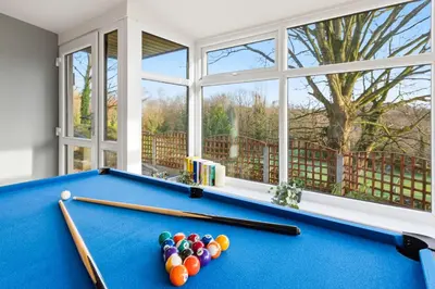 a pool table in a living room with windows at Spacious 4B home, great for contractors and families in Wigan