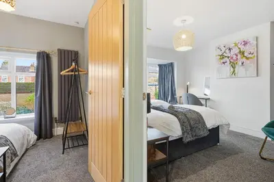 a bedroom with a bed and a desk and a window at Spacious 4B home, great for contractors and families in Wigan
