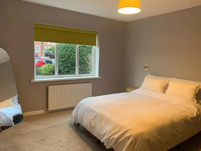 a bedroom with a large bed and a window at Seaside Serenity in Lytham St Annes