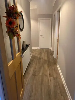 an empty hallway with a door and a flower wreath at Seaside Serenity in Lytham St Annes