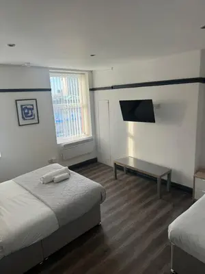 a bedroom with two beds and a flat screen tv at The residency appartment's in Litherland